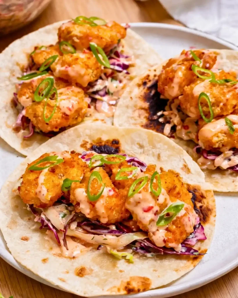 crispy air fryer bang bang shrimp tacos with creamy sauce and cabbage slaw