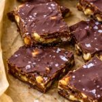 Chocolate date bark broken into rustic pieces on parchment paper,